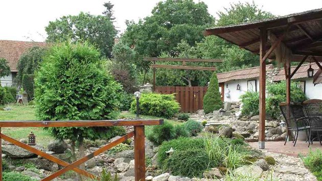 Uzavřený dvůr ve znamení kamene, dřeva a svěží zeleně. Vysazené jehličnany... Uzavřený dvůr ve znamení kamene, dřeva a svěží zeleně. Vysazené jehličnany...
