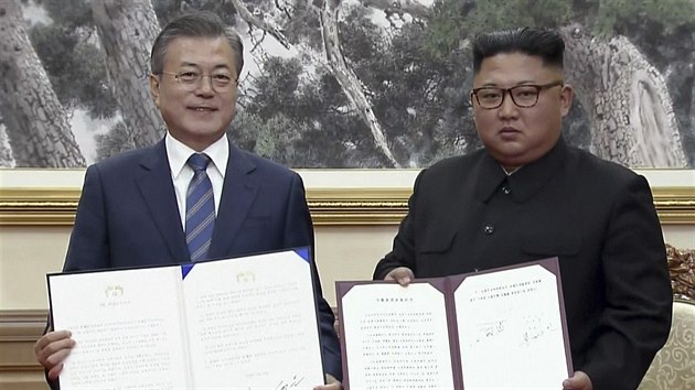 Jihokorejsk prezident Mun e-in (vlevo) a vdce KLDR Kim ong-un pzuj s podepsanmi dokumenty o vzjemn spoluprci.