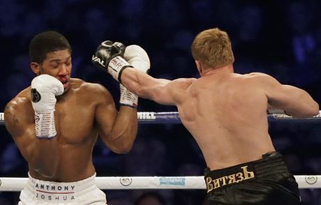 British boxer Anthony Joshua, left, his nose bleeding, fights Russian boxer...