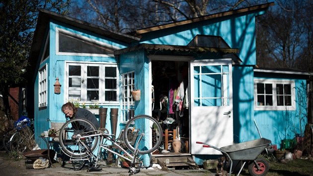 Obyvatelka jednoho z dom v Christianii si prv opravuje kolo. (13. bezna 2012)