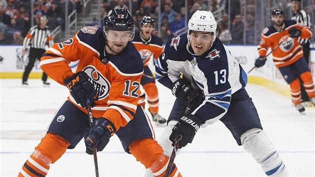 Jakub Jebek z Edmontonu (vlevo) a Brandon Tanev z Winnipegu bojuj o puk.