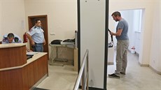 Před cestou k soudu musí všichni odložit kovové předměty na pás a projít... Před cestou k soudu musí všichni odložit kovové předměty na pás a projít...