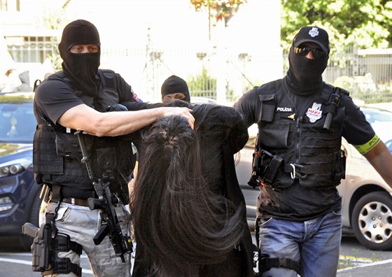 Maskovaní policisté vedou Alenu Zsuzsovou k trestnímu soudu v Banské Bystrici....