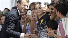 Francouzský prezident Emmanuel Macron pózuje s mladými k selfíku na...