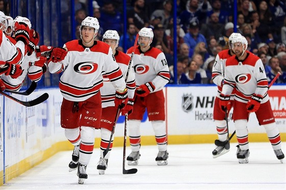 Martin Neas pijímá gratulace spoluhrá z Caroliny k premiérovému gólu v NHL.