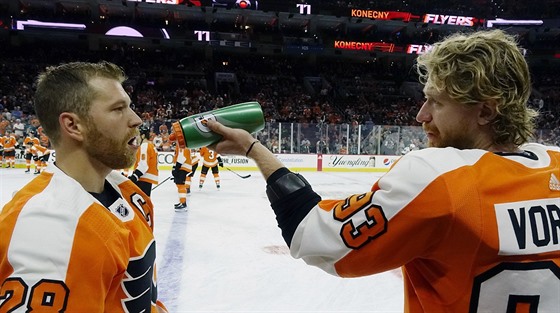 Jakub Voráček (vpravo) z Philadelphie občerstvuje při rozbruslení před zápasem...