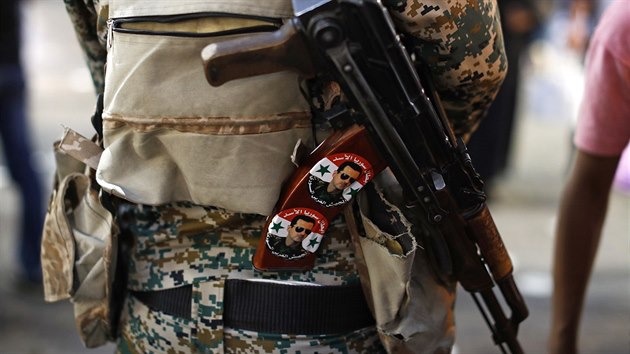 Syrsk vojk m pes rameno zbra AK-47, na kter m pipevnn odznaky s podobiznou prezidenta Bara Asada. (19. ervence 2018)