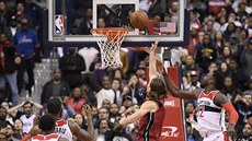 Kelly Olynyk (v červeném) z Miami dopichuje míč do koše Washingtonu, neubránil... Kelly Olynyk (v červeném) z Miami dopichuje míč do koše Washingtonu, neubránil...