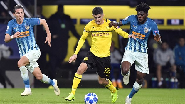 Dortmundsk zlonk Christian Pulisic (uprosted) se sna uniknout dvojici brncch hr Atltika Madrid.