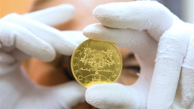 Zlat pamtn mince s motivy nrodnch symbol.