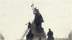 Lidé upevují eskou vlajku na kopí sochy sv. Václava na Václavském námstí....