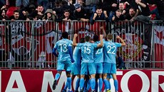 Fotbalisté Slavie se radují z gólu ped kotlem svých fanouk.