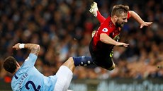 Luke Shaw z Manchesteru United (vpravo) padá na trávník po stetu s Kylem...