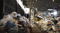 Po pásu jede plast do třídicí linky, kde už čekají pracovnice, aby ho... Po pásu jede plast do třídicí linky, kde už čekají pracovnice, aby ho...