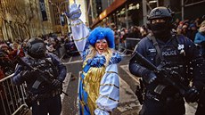 A clown performs as heavily armed police stand guard along Sixth Avenue during... A clown performs as heavily armed police stand guard along Sixth Avenue during...