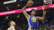 Damian Jones (vpravo) z Golden State smeuje do koe Orlanda, sleduje ho Nikola...