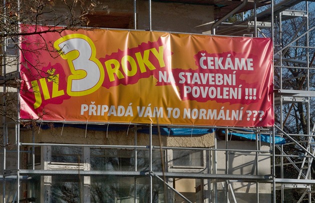 Plakát upozorující na prtahy spojené se stavebním povolením visí na bývalé...