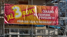 Plakát upozorňující na průtahy spojené se stavebním povolením visí na bývalé... Plakát upozorňující na průtahy spojené se stavebním povolením visí na bývalé...
