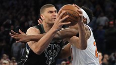 Brook Lopez (u míe) z Milwaukee se tlaí kolem Mitchella Robinsona z New Yorku.