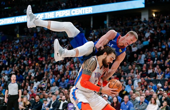 Mason Plumlee (nahoe) z Denveru padá na Stevena Adamse z Oklahoma City.