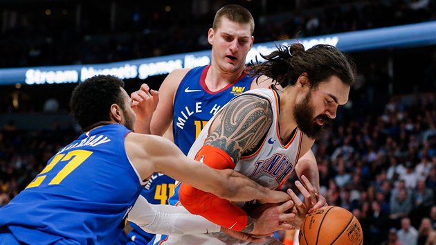 Steven Adams z Oklahoma City se dere mezi Jamala Murraye (vlevo) a Nikolu Jokie z Denveru.