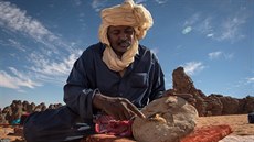 Tuareg krají chleba. Tuaregové jsou kočovní pastevci, kteří jako jedni z mála... Tuareg krají chleba. Tuaregové jsou kočovní pastevci, kteří jako jedni z mála...