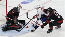 Gólman Caroliny Scott Darling zasahuje proti stele Jakuba Vrány z Washingtonu.