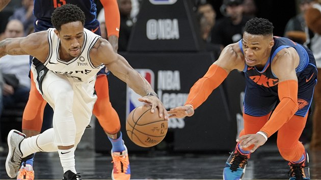 DeMar DeRozan (vlevo) ze San Antonia a Russell Westbrook z Oklahoma City bojuj o m.