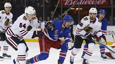 Pavel Bunevi (v modrém) z NY Rangers ujídí Davidu Kämpfovi (64) a Eriku...