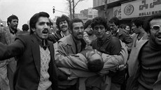 Íránci odnáejí ranného z protivládní demonstrace v Teheránu. (prosinec 1978)