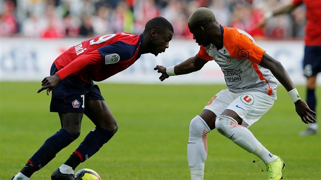 Nicolas Pepe z Lille (vlevo) u balonu, zastavit se ho sna Ambroise Oyongo z Montpellieru.