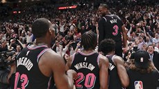 Dwyane Wade z Miami slaví se spoluhrái a fanouky vítznou trojku proti Golden...