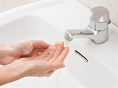 41263293 - closeup shot of a woman washing hands with soap lather over bathroom sink. girl cleaning hand.