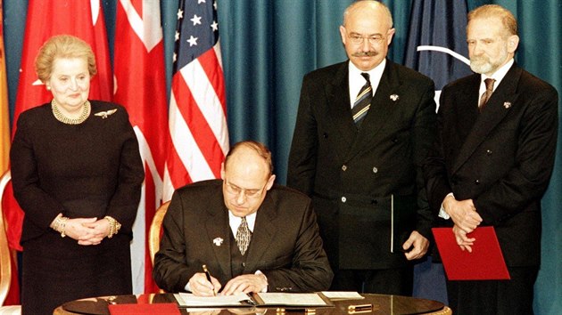 Ministr zahrani R Jan Kavan podepisuje protokol o pedn ratifikanch dokument v ptomnosti ministryn zahrani USA Madeleine Albrightov (vlevo) a ministr zahrani Maarska a Polska.