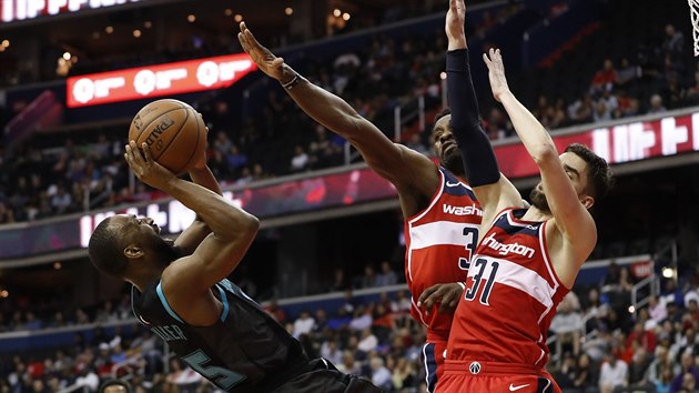 Tom Satoransk (vpravo) a Jeff Green z Washingtonu zastavuj Kembu Walkera z Charlotte.