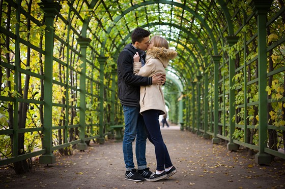 Young girl and a guy are walking through the Park, hugging and kissing. romantic mood