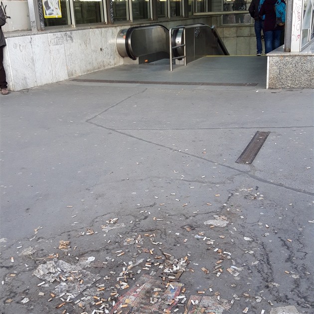 Sešlapané nedopalky cigaret při vstupu do metra Pankrác.