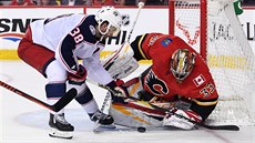 David Rittich hlídá branku Calgary ped Boonem Jennerem z Columbusu.