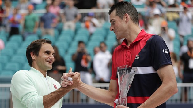 Roger Federer (vlevo) pijm gratulace od Johna Isnera po jejich vzjemnm souboji ve finle turnaje v Miami, kter jasn ovldl vcar.