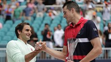 Roger Federer (vlevo) pijímá gratulace od Johna Isnera po jejich vzájemném...