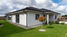 Přesah střechy i hmota garáže tvoří kolem hlavního vstupu závětří chránící před... Přesah střechy i hmota garáže tvoří kolem hlavního vstupu závětří chránící před...