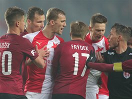 Rozhod Karel Hrube ukliduje fotbalisty Slavie (v ervenoblm) a Sparty.