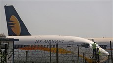 Dlníci zakrývají sklo kokpitu letadla indických aerolinek Jet Airways na...