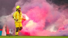 Hasič odnáší z trávníku světlici v utkání belgické ligy mezi Standardem Lutych... Hasič odnáší z trávníku světlici v utkání belgické ligy mezi Standardem Lutych...