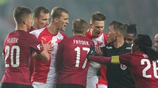 Rozhodčí Karel Hrubeš uklidňuje fotbalisty Slavie (v červenobílém) a Sparty. Rozhodčí Karel Hrubeš uklidňuje fotbalisty Slavie (v červenobílém) a Sparty.