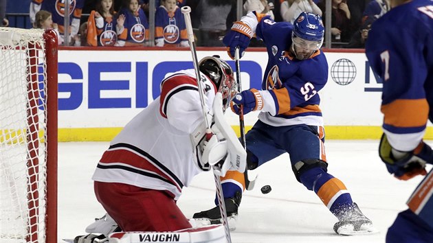 Casey Cizikas z NY Islanders zkou pekonat Petra Mrzka v brance Caroliny.