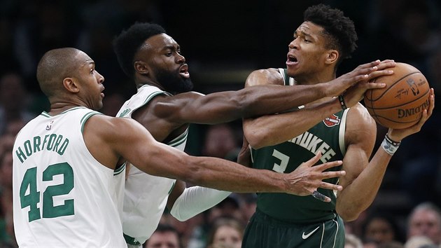 Giannis Antetokounmpo z Milwaukee se sna prosadit proti bostonskmu duu Al Horford (vlevo) a Jaylen Brown.