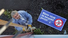 Starosta Poustky Jan Ryba vyvěšuje hrábě na stožár na obecním úřadě jako... Starosta Poustky Jan Ryba vyvěšuje hrábě na stožár na obecním úřadě jako...