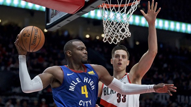 Paul Millsap (vlevo) z Denveru se chyst rozehrt, sleduje ho Zach Collins z Portlandu.