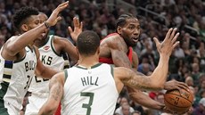 Kawhi Leonard (vpravo) z Toronta vyhlíí spoluhráe, brání ho Janis Adetokunbo...